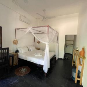 阿鲁甘湾Agra Arugambay的一间卧室配有一张带天蓬的床