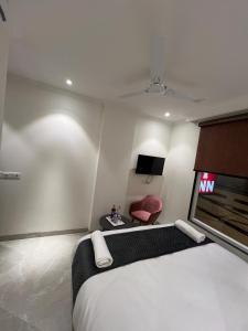 新德里HOTEL IVORY INN NEW DELHI At IGI AIRPORT的一间卧室配有一张大床和一张红色椅子