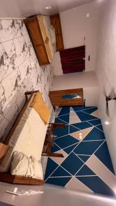 BhāgamandalaLucky star hotel的客房设有两张双层床,铺有蓝色瓷砖地板。