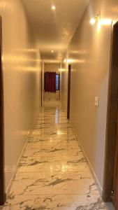BhāgamandalaLucky star hotel的走廊上设有大理石地板和长长的走廊