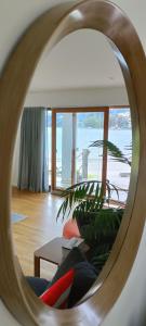 但尼丁New luxury waterfront accommodation的客厅的沙发反射镜