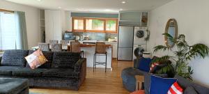 但尼丁New luxury waterfront accommodation的带沙发的客厅和厨房