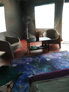 Kampung Hulu Calukthesanctuary@telagapapan的客厅配有桌子和两把椅子