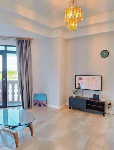 古晋Cozzzy hut Riverbank Suites Kuching with spectacular River view的客厅配有玻璃桌和吊灯。