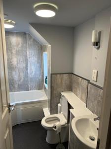 考斯联合宾馆的浴室配有卫生间、盥洗盆和浴缸。