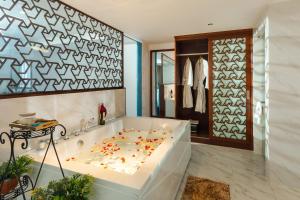 芽庄TND Hotel的地板上设有带鲜花浴缸的浴室