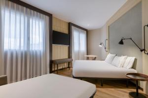 瓦伦西亚巴伦西亚AC万豪酒店的酒店客房设有两张床和窗户。