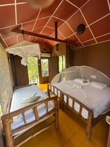 蒂瑟默哈拉默亚拉生态树屋酒店的配有2张床的天花板客房