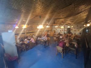 瓜隆岛Roomy Guesthouse的一群坐在餐厅桌子上的人