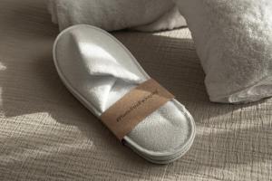 贝尼卡西姆Albades Hotel & Spa - Adults Only的一只鞋,上面有标签,坐在床上