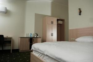 埃里温Colette Hotel的一间卧室配有一张床和一个木制橱柜