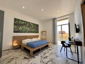 阿格里真托艾斯库秀酒店的一间卧室配有一张床、一张书桌和一个窗户。