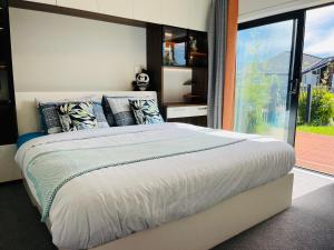 汉密尔顿Modern Comfy 3 Bedrooms House in Chartwell的一间卧室设有一张大床和一个大窗户