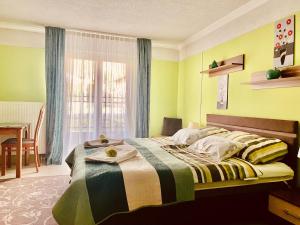 赫维兹力士旅馆的一间卧室配有一张带桌子和窗户的床