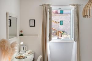 斯普利特Central Split rooms and apartments Paese的白色的客房设有窗户、桌子和水槽