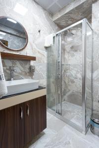 伊斯坦布尔Dream Park Hotel的一间带玻璃淋浴和水槽的浴室