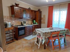 GiardinelloAppartamento in Villa Lory的一间带桌椅的厨房和一间带炉灶的厨房