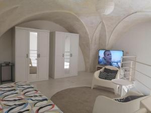 卡萨拉诺loft corte pisanelli的一间卧室配有一张床,并在一间客房内配有电视。