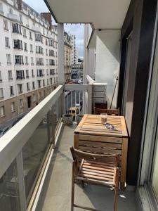 巴黎APPARTEMENT + Parking 45m2 TOUR EIFFEL的大楼内的阳台配有桌椅