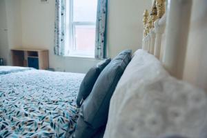 HunsletPEACEFULLY AND CENTRALLY LOCATED DOUBLE BEDROOM的一间卧室配有一张带蓝色枕头的床和一扇窗户。