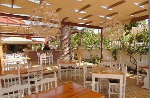 圣乔治斯The Blue Sea Hotel的餐厅设有白色的桌椅和吊灯。