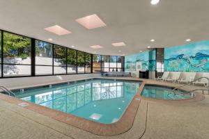 哈里斯堡哈里斯堡华美达酒店的一座大型游泳池,位于一座带窗户的建筑内