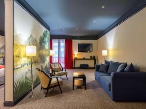 波尔多波尔多夏特龙城堡美居酒店的一间带蓝色沙发的客厅和一间卧室