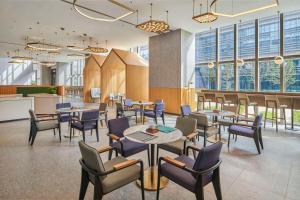 苏州苏州吴中希尔顿花园酒店的餐厅设有桌椅和窗户。