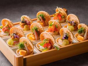 北斗市Grand Mercure Yatsugatake Resort & Spa的装满不同种类食物的木托盘