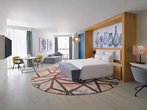 马斯喀特Mövenpick Hotel & Apartments Ghala Muscat的一间卧室设有一张床和一间客厅。