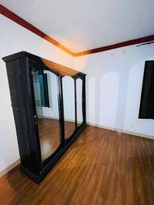 MutumbaEddy's的一间空房间,铺有木地板,配有镜子