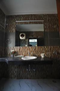 古尔冈Vagmi Inn的一间带水槽和镜子的浴室