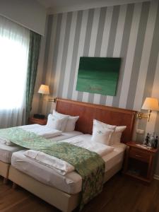 汉诺威Self-Service by Hotel Savoy Hannover的一间卧室设有两张床,墙上挂着一幅绿色画作