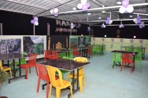 奥兰加巴德Hotel Karan International ,Aurangabad的用餐室配有桌子和五颜六色的椅子