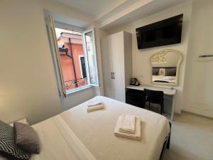 蒙特罗索阿尔马雷苏尔阿科房东酒店的一间卧室配有一张床、一张书桌和一个窗户。