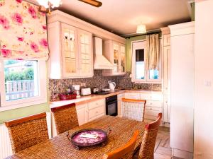 沃洛斯Blue Bay Villa的厨房配有桌子、椅子、桌子和窗户。