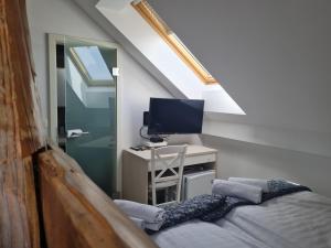 卢布尔雅那AZUR ROOMS LJUBLJANA的客房设有一张床、一张书桌和电视