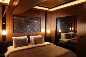 斯科普里Hotel Macedonia Square的一间卧室配有两张床和两面镜子及灯。
