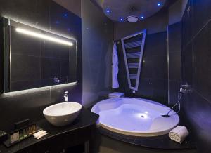 米兰Mia Boutique Hotel的一间带大浴缸和水槽的浴室