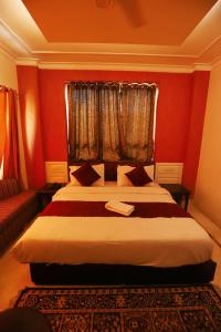 古尔冈Vagmi Inn的一间卧室设有一张红色墙壁和窗户的床