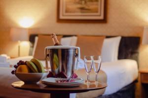 坎特伯雷豪菲尔德庄园酒店的一张桌子,上面放有两杯酒和一盘水果