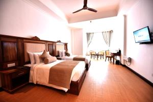 努沃勒埃利耶Araliya Red - Lean Luxury的一间带大床的卧室和一间餐厅