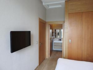 卡萨布兰卡Anfa Place, Luxury Apartment just renovated, Ocean View的卧室配有壁挂式平面电视。