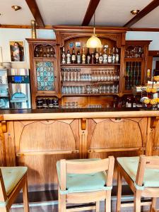 SchalksmühleHotel zur Post的酒吧配有两把椅子和柜台