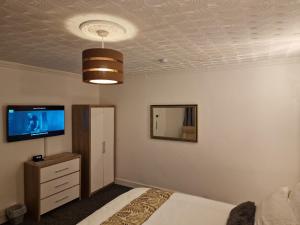 BuckinghamshireSteyn Guest Lodge的一间卧室设有一张床,天花板上配有电视。