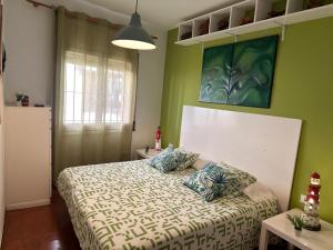 帕拉莫斯Apartamento con jardín a 11 metros de la playa. B3.的一间卧室设有一张床和绿色的墙壁