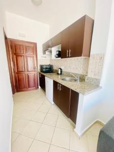 卡博尼格洛Cabo Dream Apparthotel的厨房配有棕色橱柜和水槽