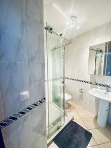 卡博尼格洛Cabo Dream Apparthotel的一间带玻璃淋浴和水槽的浴室