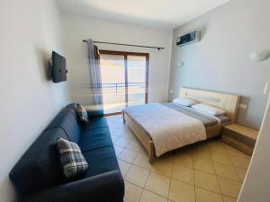 卡博尼格洛Cabo Dream Apparthotel的一间卧室配有一张床和一张蓝色的沙发