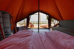 法鲁Glamping Camp Faro的一间卧室配有带一张床的橙色帐篷